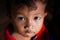 Portrait of a Khmer little boy with spot light pointing on him, cute black eyes looking up at camera