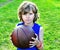 Portrait of a kid with a basketball on grass