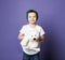 Portrait of kid boy in green hat showing us his favorite toy polar bear on purple. International day of polar bear concept