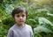 Portrait of kid standing in tropical rain forest, Active little boy looking at camera with couriouse face. Child having adventure