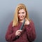 Portrait of killer woman with knife against gray background