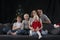 Portrait of large friendly family on Christmas Eve. Mom dad and three children at home on Christmas tree background