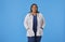 Portrait of a latin internist woman looking at camera smiling with her hands on pockets of uniform