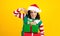 Portrait of Latin mature woman holding Christmas gift box on a yellow background in Mexico latin america