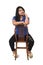 Portrait of a Latin woman sitting on a chair that is turned on white background, look up