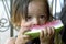 Portrait Latino little girl eating watermelon