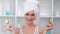 Portrait of laughing female in towel on head covered eyes by cucumber slice 4k footage