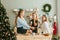 Portrait of laughing girlfriends having christmas snacks in christmas kitchen