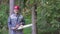 Portrait of laughing worker in a helmet with a chainsaw in the forest