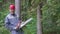 Portrait of laughing worker in a helmet with a chainsaw in the forest