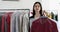 Portrait of laundry girl holding a hanger with clothes in dry cleaners