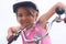 Portrait of a litte Cacasian girl in a pink safety helmet driving her bike.