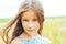 portrait of a little adorable girl with long hair in the field