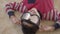 Portrait of little african american boy lying on the floor on the beige fluffy carpet with paintball glasses on his eyes