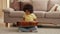 Portrait little African American girl taps palms on surface of wooden guitar creating musical rhythm. Teenage girl sits