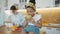 Portrait of little Afro American preschool girl in white T-shirt and with yellow bandage on his hair. Sitting in kitchen