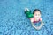 Portrait of little Asian child girl in a mermaid suit sitting and lying poolside with looking camera