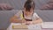 Portrait of little Asian girl child study learn at home smile and happiness.Cute girl drawing and handwriting in notebook to