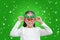 Portrait of little Asian girl in reindeer costume with floating snow on green christmas background