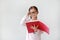 Portrait of little Asian Schoolgirl wearing eyeglasses and holding notebook with pencil on white background