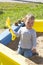 Portrait of a little baby boy girl playing in a sandbox with a yellow plastic shovel. Cute kid on a walk playing with sand,