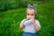 Portrait of a little baby chews his shoe on a grass