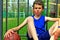 Portrait of a little basketball player sitting on the court