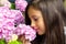 Portrait of a little beautiful girl with a bouquet of hydrangeas in her hands.