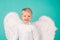 Portrait of little blond Angel boy. Child with angelic white dress. Toddler boy wearing angel costume, white dress and