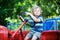 Portrait of little blond boy in tractor in summer