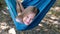Portrait of a little blond caucasian girl lying in a blue hammock outdoors on a sunny day. Vacation for children, rest