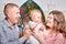 Portrait of a little blonde girl, plump chubby mother and big father. Family in studio during photo shoot