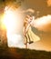 Portrait of a little blonde smiling girl in a dress at sunset