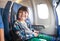 Portrait of little boy in airplane seat by window