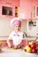 Portrait of little boy in the hat of the chef and an apron. Little chef cooks in the kitchen.Portrait of cute boy helping at