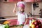 Portrait of little boy in the hat of the chef and an apron. Little cooks chef in the kitchen tasting the dish.