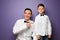 Portrait of little boy and his father in classic shirts on color background