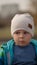 Portrait of a little boy in a park bench, the child looks suspiciously