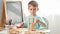 Portrait of little boy playing with wooden toy blocks and building tower from bricks. Concept of smart children and home