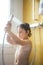 Portrait of little boy pouring shower on head