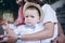 Portrait of the little boy. He sits on the stairs with parents on his mother`s knees. Image with selective focus on the child.