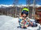 Portrait of little boy snowboarder in mountains