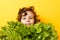 Portrait of little boy standing isolated on yellow background and enjoying delicious lettuce while looking at camera. Concept of
