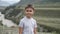 Portrait. Little boy tourist looking at the camera on a background of mountains and a river