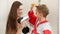 Portrait of little boy and young mother drying hair with hairdryer in bathroom. Concept of child hygiene and health care