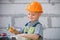 Portrait of little builder in hardhats with instruments for renovation on construction. Builder boy, carpenter kid with