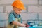 Portrait of little builder in hardhats with instruments for renovation on construction. Builder boy, carpenter kid with