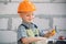 Portrait of little builder in hardhats with instruments for renovation on construction. Builder boy, carpenter kid with