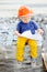 Portrait of little builder in hardhats reading construction drawing