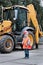 Portrait of little builder in hardhats working outdoors near Tractor excavator.